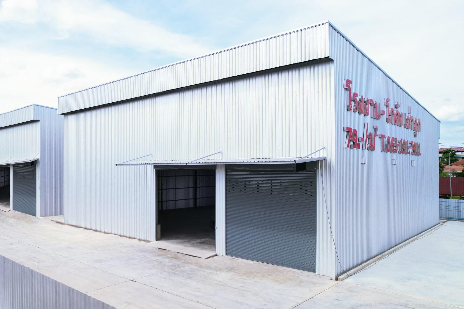 ภายโกดังวังน้อยมุมด้านหน้าเอียง 45 องศาเห็นประตูางเข้าโกดังและถนนโครงการ